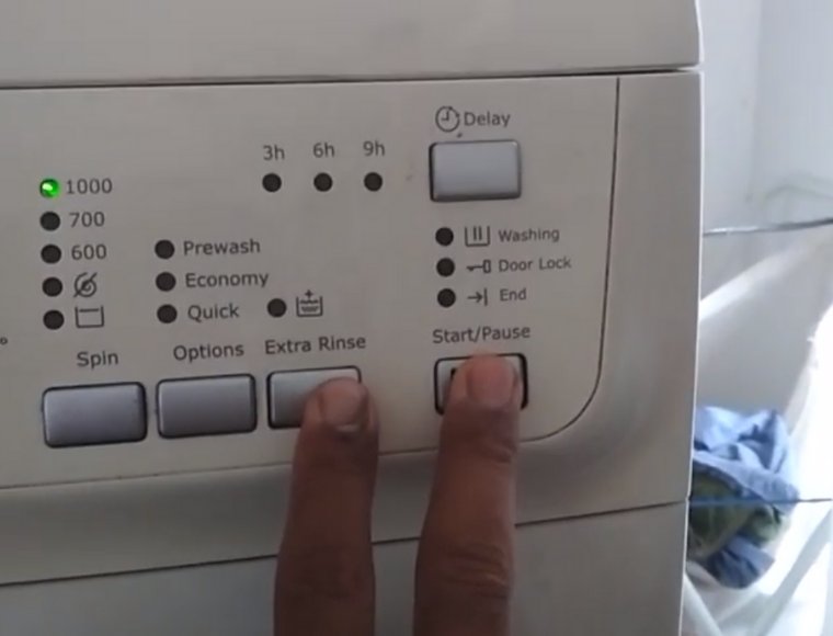 Tombol Extra Rinse dan Start pada mesin cuci Electrolux yang ditekan bersamaan